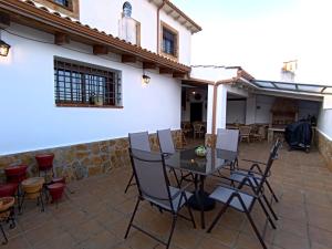 a patio with a table and chairs in front of a building at Alojamiento Rural El Ojuelo in El Ojuelo