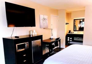 フローレンスにあるClarion Inn & Suitesのベッド、デスク、テレビが備わるホテルルームです。