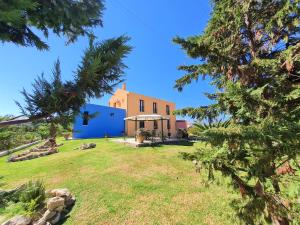 a house with a blue building and trees at Casa Spannika Pool And Gym in Zakynthos Town