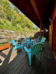 une terrasse pourvue de chaises bleues et d'une table. dans l'établissement Chalet Des Feignes, à La Bresse