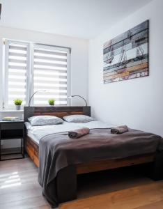 a bedroom with a large bed with a wooden frame at Apartament z widokiem, 10min od morza in Gdańsk