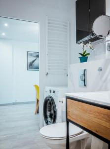 a bathroom with a washing machine and a sink at Apartament z widokiem, 10min od morza in Gdańsk
