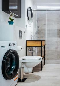 a bathroom with a toilet and a washing machine at Apartament z widokiem, 10min od morza in Gdańsk