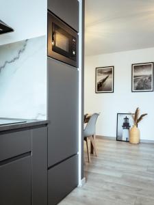 a kitchen with a refrigerator and a dining room at Apartament z widokiem, 10min od morza in Gdańsk