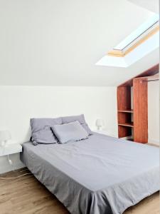 uma cama num quarto com uma parede branca em T2 Belle vue renové centre ville em Valence