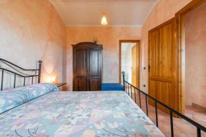 1 dormitorio con 1 cama y puerta de madera en Casa Giovanna e Antonio en Calasetta