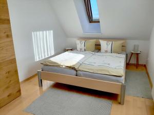 ein Schlafzimmer mit einem Bett in einem Zimmer mit einem Fenster in der Unterkunft Atelier Grünfink Ferienwohnung in Clausnitz
