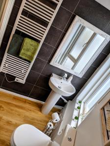 La salle de bains est pourvue d'un lavabo et d'un miroir. dans l'établissement Spacious contemporary apartment, à Ramsgate