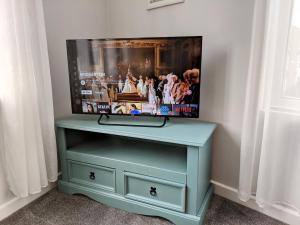 a blue dresser with a tv on top of it at Spacious contemporary apartment in Ramsgate