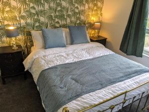 a bedroom with a bed with blue pillows at Spacious contemporary apartment in Ramsgate