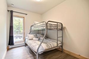 a bunk bed in a room with a window at Sutton Wellness Cabin #265 unité du haut in Sutton