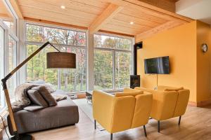 a living room with a couch and chairs and a tv at Wellness Sutton Cabin #265 unité du haut in Sutton