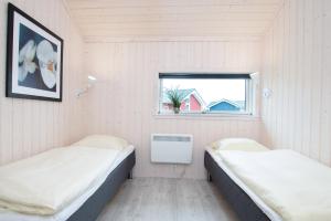 2 Betten in einem Zimmer mit Fenster in der Unterkunft Resort 2 Ocean Cottage A 77 in Großenbrode
