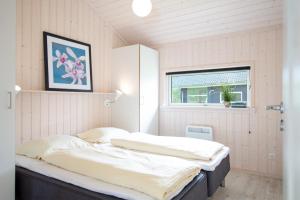 - une chambre avec un lit doté de draps blancs et une fenêtre dans l'établissement Resort 2 Sea Lodge C 112, à Großenbrode