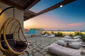 a patio with a bunch of chairs and a hammock at White Swan in Rethymno Town