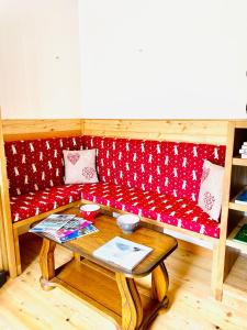 un sofá rojo con una mesa en una habitación en La Sabaudia en Saint-Pierre-dʼEntremont