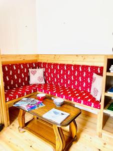 a red couch with a table in a room at La Sabaudia in Saint-Pierre-dʼEntremont