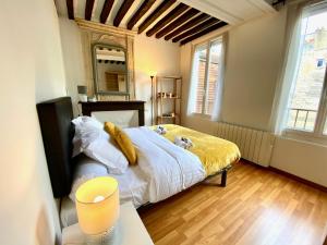 um quarto com uma cama grande e um cobertor amarelo em Nashira YourHostHelper em Caen