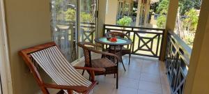a balcony with a table and chairs on a balcony at Hostellerie La Digue in La Digue