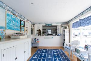 a kitchen with blue and white walls and a blue rug at A Beach Breeze Inn in West Harwich