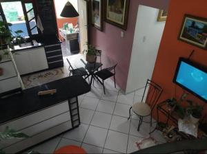 sala de estar con TV, mesa y sillas en Hospedaria Green en Florianópolis
