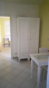 イヴレーアにある...per il Sirioの白いキャビネットと白いテーブルが備わる客室です。