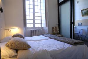 a bedroom with two beds with pillows and a window at EUGENIE: 1 er ETAGE in Luchon