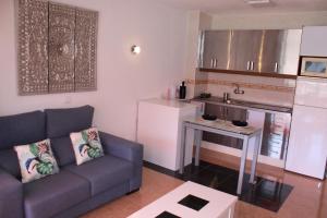 a living room with a couch and a kitchen at Tropical Canary Home - Playa Del Ingels in Playa del Ingles