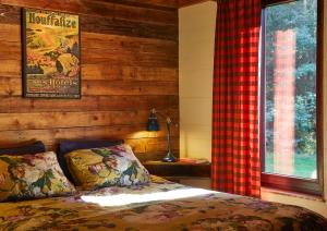 Schlafzimmer mit einem Bett und einem Fenster in der Unterkunft Chalet Mont Juru - Romantisch 2-persoons Chalet in Houffalize