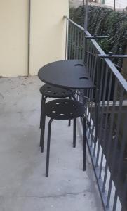 イヴレーアにある...per il Sirioの手すりの横に座る黒いテーブルと椅子