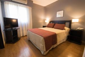ein Hotelzimmer mit einem Bett und einem TV in der Unterkunft Gran Hotel Buenos Aires in Buenos Aires