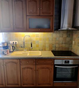 a kitchen with wooden cabinets and a sink at Family house by the seaside of Karavostasis in Karavostasi