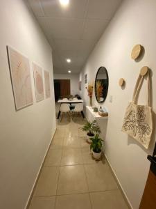 a hallway with white walls and a table and a mirror at Studio Estrada 2 Escobar in Belén de Escobar