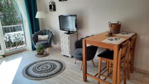 a living room with a desk and a tv at les dryades in Gérardmer