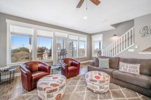 a living room with leather furniture and windows at Driftwood Pearl in Lincoln City