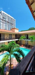 a resort with a palm tree and a swimming pool at Najhomi Beach in Santa Marta
