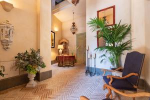 a hallway with plants and a chair and a mirror at Real Casa de la Moneda Deluxe Apartments in Seville
