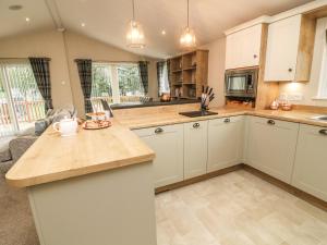 a kitchen with white cabinets and a counter top at The Warren in Skipton