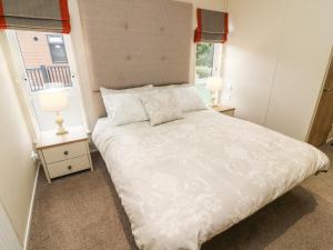 a bedroom with a large white bed with two lamps at The Warren in Skipton