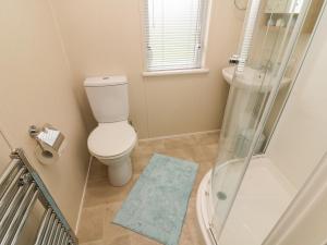 a small bathroom with a toilet and a shower at The Warren in Skipton +8 photos