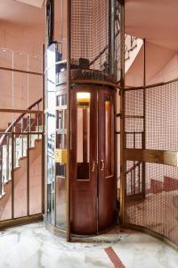 eine große Holztür mit einem Vogelkäfig dahinter in der Unterkunft 8cento al Valentino in Turin