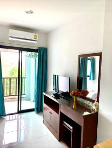 a living room with a desk and a mirror at Baan Chomphu Pakchong in Ban Nong Sarai (1)