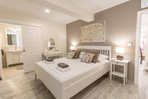 a bedroom with a large white bed and a bathroom at Apartments Vintage in Rab
