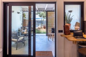 a glass door leading to a dining room with a table at Papaya Beach Studios in Tarifa