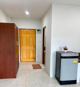 a hallway with a wooden door and a refrigerator at Baan Chomphu Pakchong 30 minutes from Khao Yai in Ban Nong Sarai (1) +5 photos