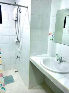 y baño blanco con lavabo y ducha. en Baan Chomphu Pakchong, en Ban Nong Sarai (1)