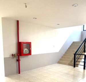 a red tv on a wall next to a staircase at Baan Chomphu Pakchong in Ban Nong Sarai (1)