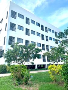 a white building with trees in front of it at Baan Chomphu Pakchong in Ban Nong Sarai (1)