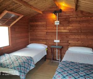 - une chambre avec 2 lits dans une cabane en rondins dans l'établissement Camping Santa Clara, à Altea