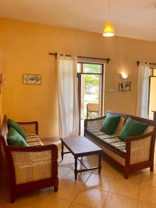 a living room with two couches and a table at Flametree Beach Homes in Diani Beach